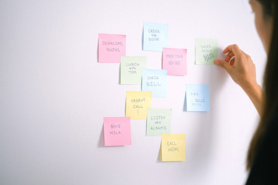 kobieta przyklejająca sticky notes do ściany