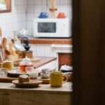 Drewniany blat kuchenny z zestawem do parzenia herbaty, kubkami i przekąskami.